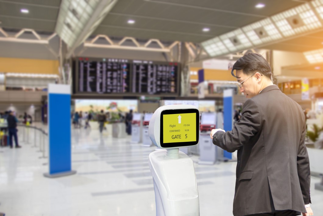 Businessmen are checking flight with intelligent robots, who serve passengers at the airport.