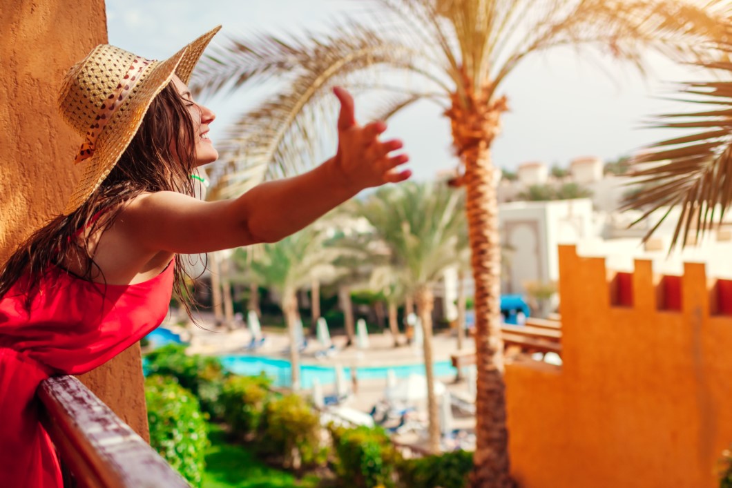 Young woman enjoying the view from hotel balcony in Egypt. Having good time in tropical resort