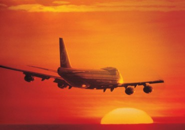 Commercial plane landing with sun sinking
