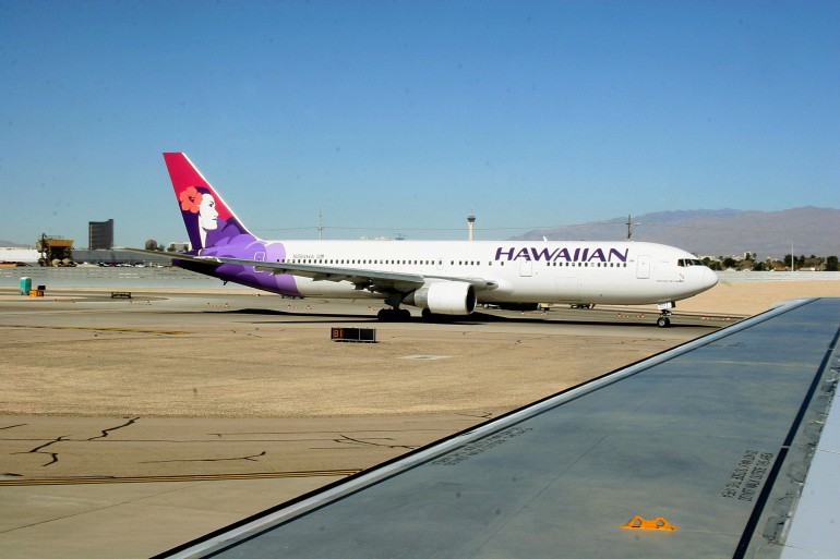 A Hawaiian Airlines jet taxies out to th