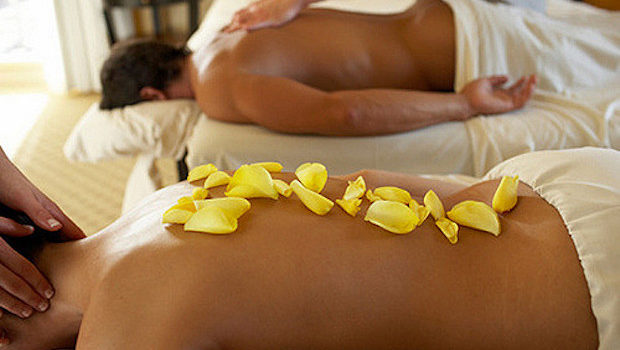 Couple receiving massage by two masseurs