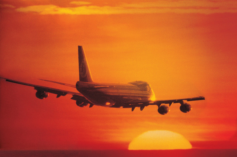 Commercial plane landing with sun sinking