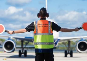 Heathrow, airfield, airfield ops marshaller guiding aircraft on apron, Sep 2018.