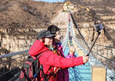 (171224) -- SHIJIAZHUANG, Dec. 24, 2017 (Xinhua) --  Tourists pose for photos on the glass suspension bridge at Hongyagu scenic spot in Pingshan County, north China's Hebei Province, Dec. 24, 2017. The 488-meter-long glass suspension bridge was formally open to the public Sunday. (Xinhua/Liu Peiran) (yxb) (Photo by Xinhua/Sipa USA)